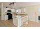 Updated kitchen featuring white cabinetry, stone countertops, and a breakfast bar at 3808 Lilac Haze St, Las Vegas, NV 89147
