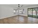 Spacious living room with light plank flooring, large windows, and a sliding door to backyard at 3916 Green Leaf Dr, Las Vegas, NV 89120