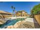 Gorgeous backyard featuring a lagoon-style pool with rock accents, lush greenery, and privacy fencing at 4 Bishopsgate Ter, Henderson, NV 89074