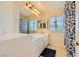 Bright bathroom with a double sink vanity, a window, and decorative blue curtain at 4 Bishopsgate Ter, Henderson, NV 89074