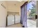 Practical laundry room with modern washer and dryer, and a view of the backyard at 4 Bishopsgate Ter, Henderson, NV 89074
