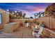 Charming outdoor space with a built-in grill, stone-lined fire pit, and cozy seating area under string lights at 4330 Oasis Hill Ave, North Las Vegas, NV 89085