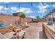 Inviting backyard with patio, stone firepit, outdoor kitchen, and charming white Adirondack chairs at 4330 Oasis Hill Ave, North Las Vegas, NV 89085