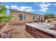 Backyard showcasing a hot tub, stone patio, and the exterior of the house at 4330 Oasis Hill Ave, North Las Vegas, NV 89085