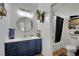 Bright bathroom with wood plank walls, modern light fixture, round mirror, and shower at 4330 Oasis Hill Ave, North Las Vegas, NV 89085