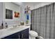 Bathroom with blue vanity, white sink, and shower featuring a patterned curtain at 4330 Oasis Hill Ave, North Las Vegas, NV 89085