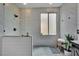 Modern bathroom featuring sleek tile shower, white paneled half wall, and light-filled window for a refreshing ambiance at 4330 Oasis Hill Ave, North Las Vegas, NV 89085