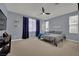 Spacious bedroom with carpet flooring, ceiling fan, and decoratively draped windows, creating a cozy atmosphere at 4330 Oasis Hill Ave, North Las Vegas, NV 89085
