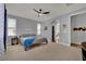 Bright bedroom featuring a ceiling fan and two windows allowing ample natural light with modern gray walls at 4330 Oasis Hill Ave, North Las Vegas, NV 89085