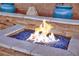 Close up on a cozy backyard fire pit with colorful blue glass stones at 4330 Oasis Hill Ave, North Las Vegas, NV 89085
