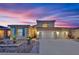 Two-story home boasting a three-car garage, tasteful landscaping, and a welcoming entrance, set against a twilight sky at 4330 Oasis Hill Ave, North Las Vegas, NV 89085