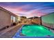 Inviting backyard with a luxurious hot tub, paved patio, and relaxing ambiance at dusk at 4330 Oasis Hill Ave, North Las Vegas, NV 89085