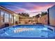 Backyard with a hot tub, grill, outdoor kitchen, fire pit, and desert landscaping at 4330 Oasis Hill Ave, North Las Vegas, NV 89085