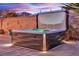 Backyard view of a modern hot tub, set against a brick wall and lush greenery, perfect for evening relaxation at 4330 Oasis Hill Ave, North Las Vegas, NV 89085