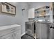 Laundry room with modern washer and dryer, storage cabinet, and decorative shelves at 4330 Oasis Hill Ave, North Las Vegas, NV 89085