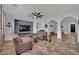 Spacious living room features tile floors, modern ceiling fan, and television with rustic wood accent wall at 4330 Oasis Hill Ave, North Las Vegas, NV 89085