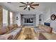 Bright living room featuring tile floors, two sofas, a ceiling fan, and a decorative rustic wood accent wall at 4330 Oasis Hill Ave, North Las Vegas, NV 89085
