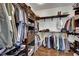 Organized walk-in closet with wooden shelves and hanging rods to maximize space and storage solutions at 4330 Oasis Hill Ave, North Las Vegas, NV 89085