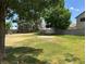 Spacious green backyard with mature trees and a hardscape area at 4375 Pittsfield St, Las Vegas, NV 89115