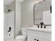 Modern bathroom featuring a double sink vanity, white cabinetry, framed mirror, and tiled shower with dark bronze hardware at 4375 Pittsfield St, Las Vegas, NV 89115