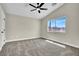 Bedroom with neutral carpet, ceiling fan, and window with an exterior view allowing lots of natural light at 4375 Pittsfield St, Las Vegas, NV 89115