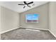 Bright bedroom with plush carpeting, ample natural light, and a ceiling fan at 4375 Pittsfield St, Las Vegas, NV 89115