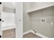 Well-lit laundry area featuring white plank flooring, shelf space, and adjacent bathroom at 4375 Pittsfield St, Las Vegas, NV 89115