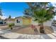 Yellow house with attractive xeriscaping, accented by mature palm and desert trees at 4419 Fairmont Cir, Las Vegas, NV 89147