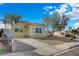 A quaint yellow house with fresh xeriscaping, a driveway, and sidewalk at 4419 Fairmont Cir, Las Vegas, NV 89147