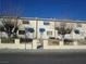 Multi-Gathering townhomes with beige exterior, small front yards, and blue awnings, offering simple curb appeal at 500 S 13Th St # C6, Las Vegas, NV 89101