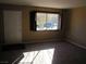 Bright living area featuring neutral walls, carpet flooring, a front door and a large window with dark shutters at 500 S 13Th St # C6, Las Vegas, NV 89101