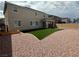 Spacious backyard featuring artificial grass, a covered patio, and rock landscaping at 5404 Scandia Lore Ct, Las Vegas, NV 89130