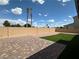 This backyard features a desert landscape with a lawn, brick pavers, block wall, and two palm trees at 5404 Scandia Lore Ct, Las Vegas, NV 89130