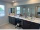 Bathroom vanity featuring double sinks and a large mirror at 5404 Scandia Lore Ct, Las Vegas, NV 89130