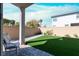 Private backyard featuring a small grass area, brick fence, and a paved patio at 63 Harrison Rose Ct, Las Vegas, NV 89110