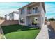Home's backyard has artificial grass and a stone path and walls at 63 Harrison Rose Ct, Las Vegas, NV 89110