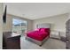 Stylish bedroom featuring plush gray carpet and a striking bed with a vivid pink comforter set at 63 Harrison Rose Ct, Las Vegas, NV 89110