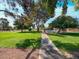 Scenic view of common area with trees, grass, and a walkway leading to a pool at 63 Harrison Rose Ct, Las Vegas, NV 89110