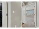 Bright hallway showcasing an open doorway and neutral decor, leading to a carpeted room with windows at 63 Harrison Rose Ct, Las Vegas, NV 89110