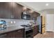 Modern kitchen with stainless steel appliances, dark wood cabinets, and stylish backsplash at 63 Harrison Rose Ct, Las Vegas, NV 89110