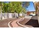 The landscaped backyard showcases a brick-lined path, mature trees, and an outdoor kitchen area at 6328 Yankee Meadow Cir, Las Vegas, NV 89130