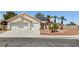 Charming single-story home featuring a two-car garage, solar panels, and desert landscaping with palm trees at 6328 Yankee Meadow Cir, Las Vegas, NV 89130