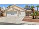 A single-story home with a two-car garage and a well-maintained yard featuring desert landscaping at 6328 Yankee Meadow Cir, Las Vegas, NV 89130