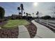 Common area with manicured lawn, walking path, white fence, and palm trees at 6459 Rusticated Stone Ave # 103, Henderson, NV 89011