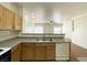 Cozy kitchen features wooden cabinets, laminate countertops, and stainless steel double sink at 6459 Rusticated Stone Ave # 103, Henderson, NV 89011