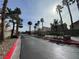 Neighborhood street lined with palm trees leads to the community's gated entrance at 6459 Rusticated Stone Ave # 103, Henderson, NV 89011