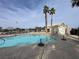 Community swimming pool surrounded by palm trees and a fenced area at 6459 Rusticated Stone Ave # 103, Henderson, NV 89011