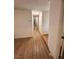 Hallway with laminate flooring and neutral walls leads to various rooms in the home at 6460 Linda Ln, Las Vegas, NV 89103