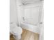 Bright bathroom features a white tile shower-tub combo and wood-look flooring at 6537 Ditmars St, Las Vegas, NV 89166