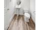 Bathroom featuring a pedestal sink, wood look floors, and a standard toilet at 6537 Ditmars St, Las Vegas, NV 89166